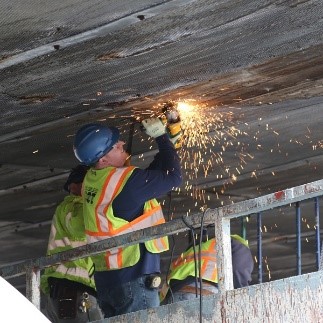 A DOT crew member makes repairs overhead to the BQE structure