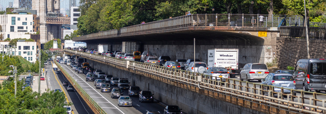 Cars and trucks travel along a busy three tiered highway in Brooklyn